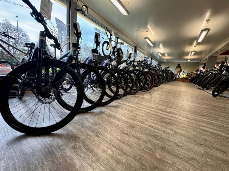 Reihe von Fahrrädern in einem Verkaufsraum mit Holzfußboden.